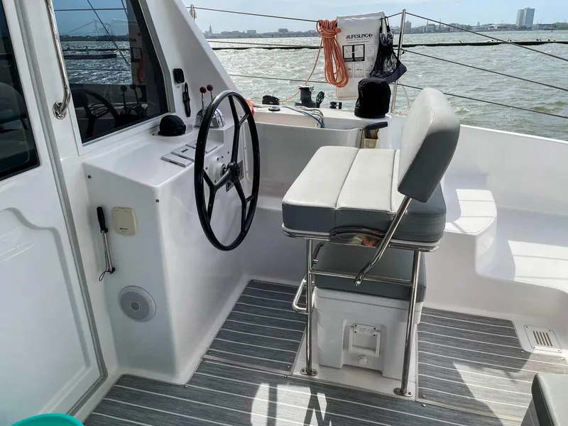 Slide: The Image of 2023 Seawind 1260 yacht cockpit with steering wheel and cushioned seat. - 8