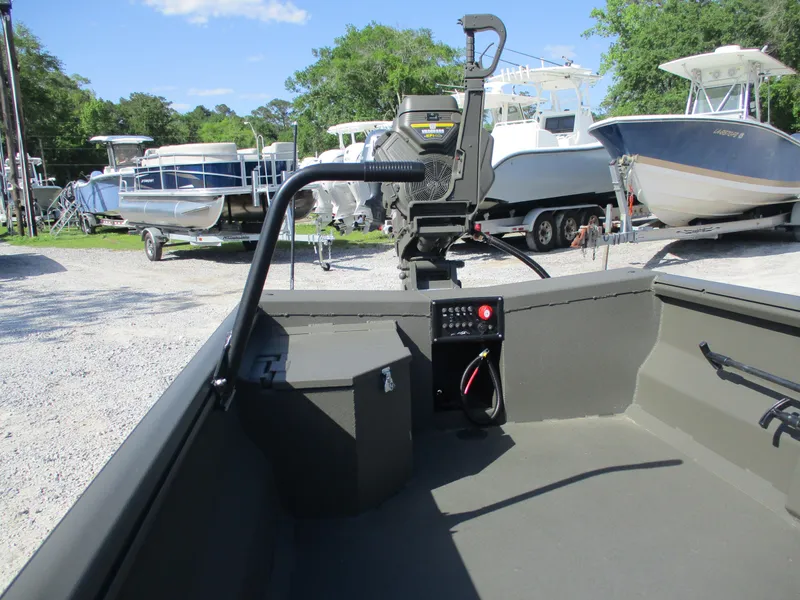 Slide: The Image of 2025 Gator Tail 1748 GATOR boat interior with control panel, parked among other boats. - 5