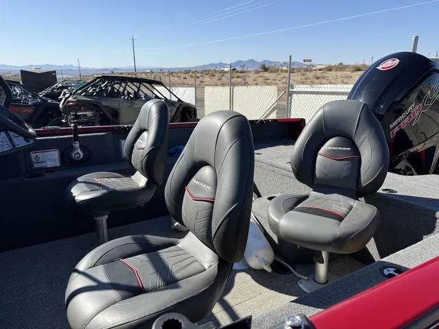 Slide: The Image of 2023 Tracker Pro Guide V-175 WT boat interior with three gray seats and Mercury engine. - 4