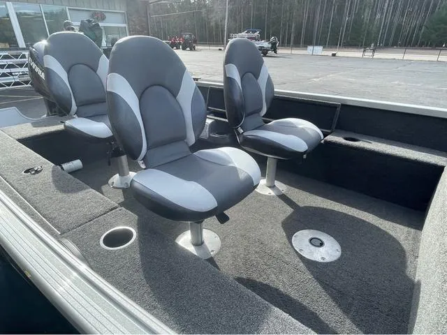 Slide: The Image of 2016 Alumacraft Classic 165 TL boat interior with two gray seats and carpeted flooring. - 10