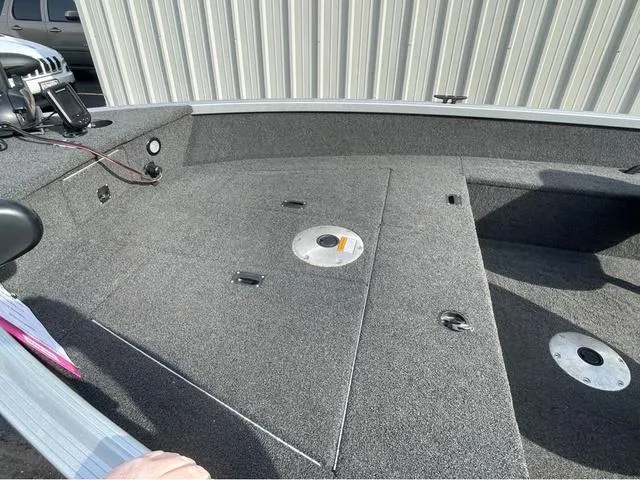 Slide: The Image of 2016 Alumacraft Classic 165 TL boat interior with carpeted deck and storage compartments. - 15