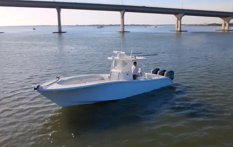 Slide: The Image of 2017 Yellowfin 34 Offshore boat cruising under a bridge on calm waters. - 0