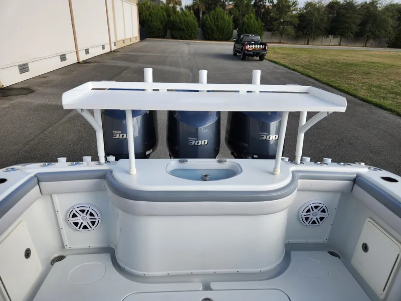 Slide: The Image of 2017 Yellowfin 34 Offshore boat with triple 300 horsepower engines, docked outdoors. - 16