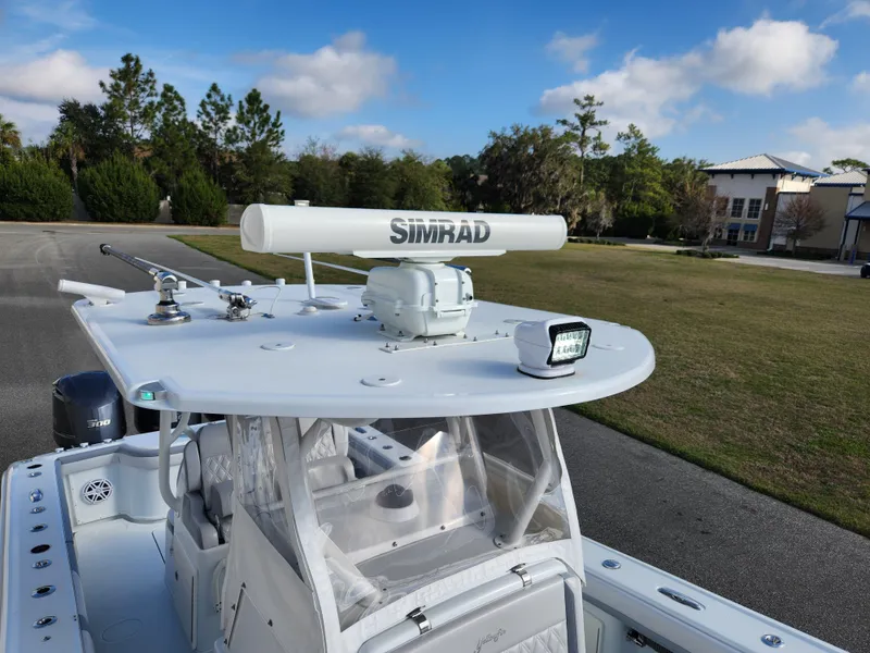 Slide: The Image of 2017 Yellowfin 34 Offshore boat with Simrad radar, parked outdoors under a blue sky. - 26