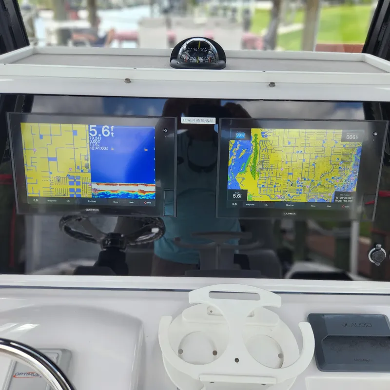 Slide: The Image of 2021 Sportsman Open 252 Center Console dashboard with dual navigation screens and compass. - 16