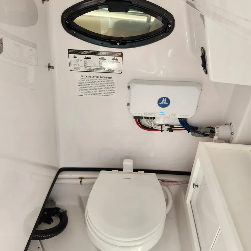 Slide: The Image of Interior of 2021 Sportsman Open 252 Center Console boat with toilet and control panel. - 18