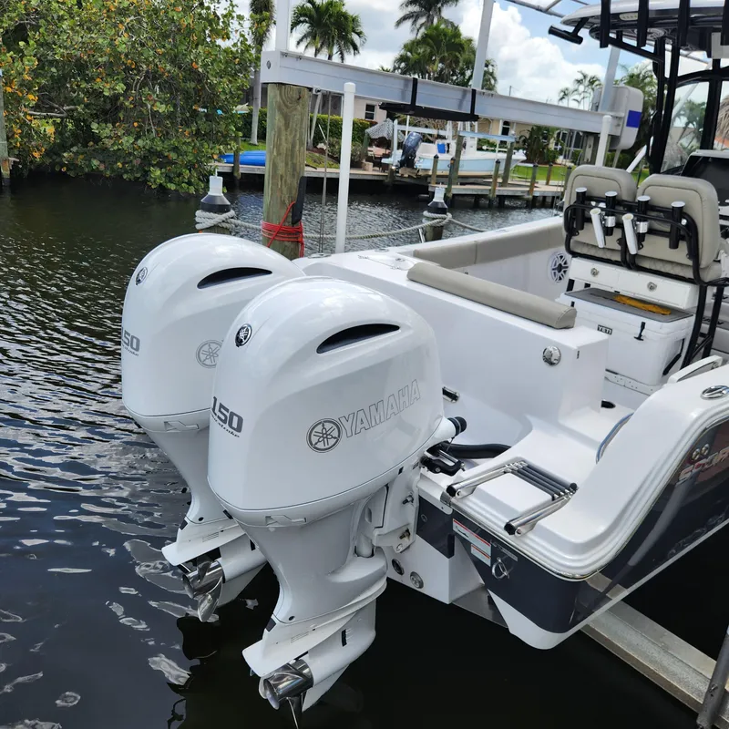Slide: The Image of 2021 Sportsman Open 252 Center Console with twin Yamaha outboard motors docked by water. - 3