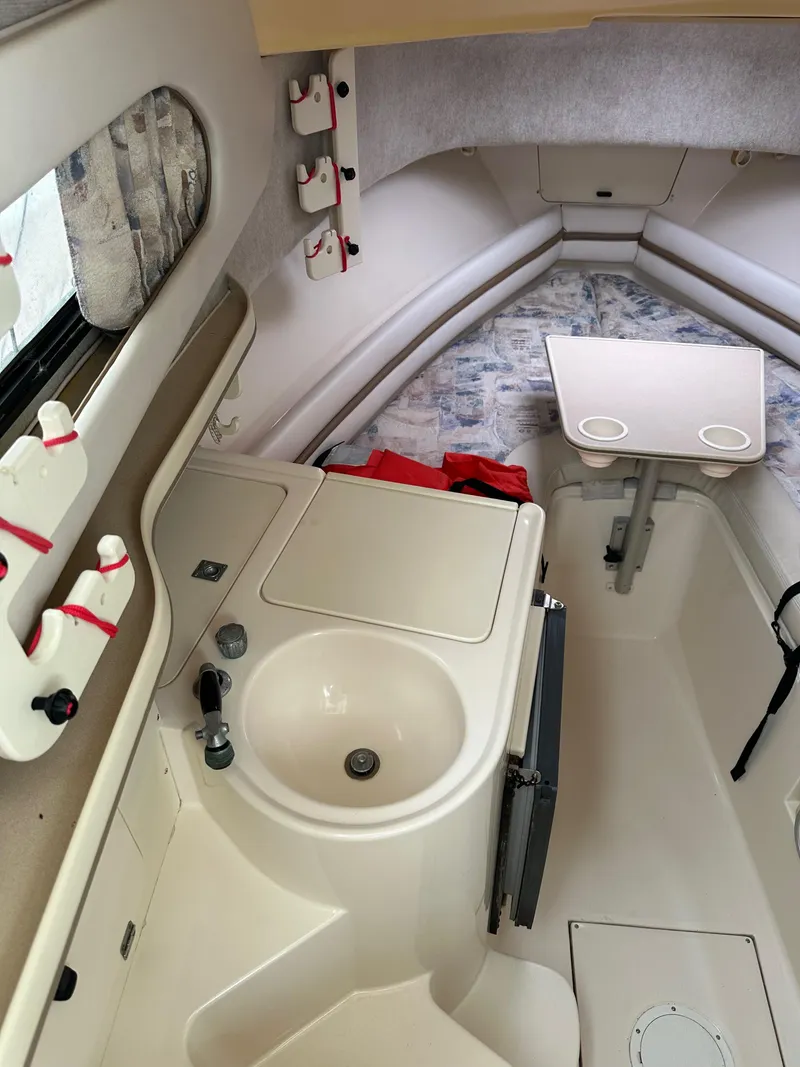 Slide: The Image of 2001 Grady-White Sailfish 282 cabin interior with sink, table, and seating area. - 22