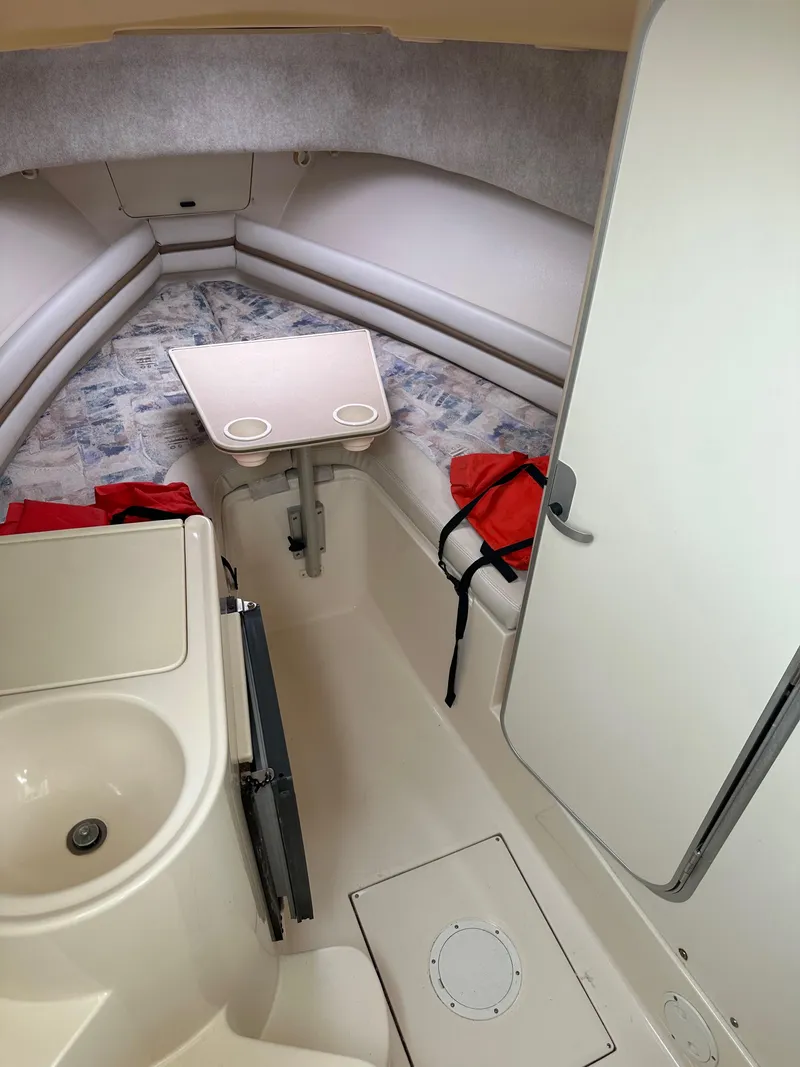 Slide: The Image of 2001 Grady-White Sailfish 282 cabin interior with seating, table, and life jackets. - 23