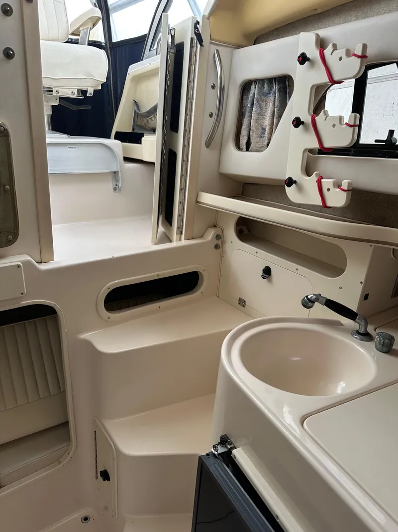 Slide: The Image of 2001 Grady-White Sailfish 282 interior with sink, storage, and seating area. - 24
