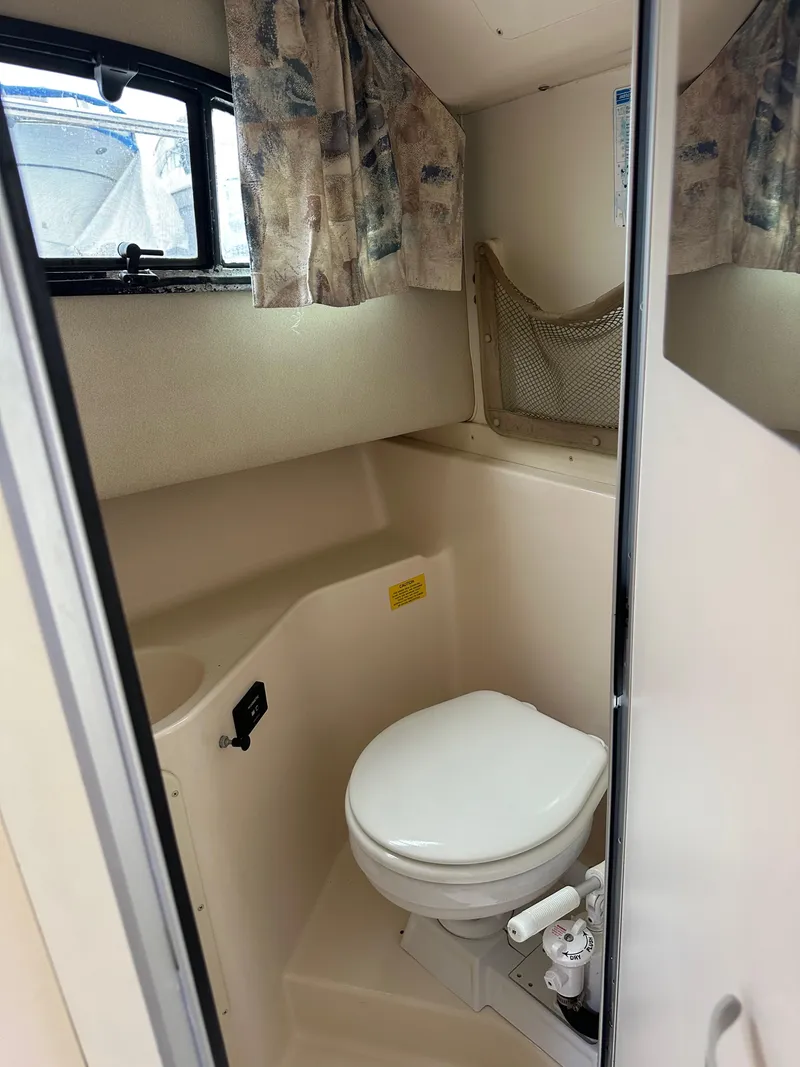 Slide: The Image of 2001 Grady-White Sailfish 282 boat bathroom with toilet and window. - 25
