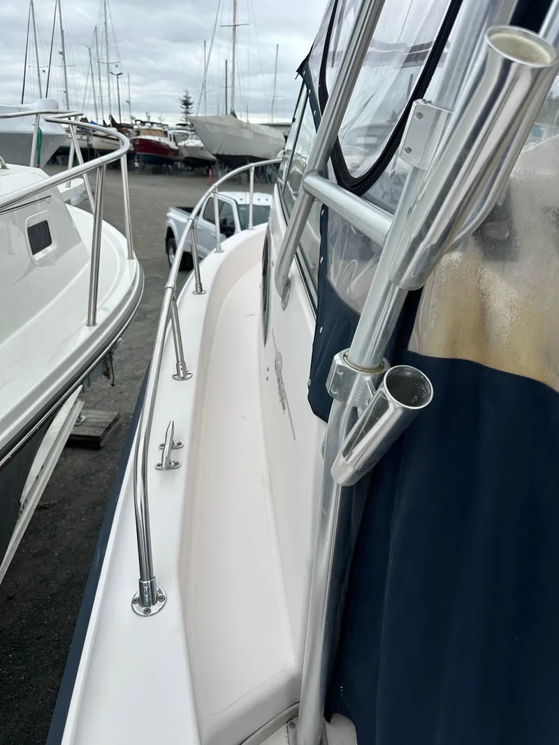 Slide: The Image of 2001 Grady-White Sailfish 282 boat docked, showcasing side railing and rod holders. - 36