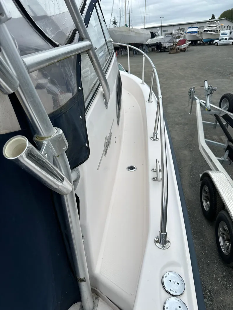 Slide: The Image of 2001 Grady-White Sailfish 282 boat, side view, docked with visible railing and trailer. - 37