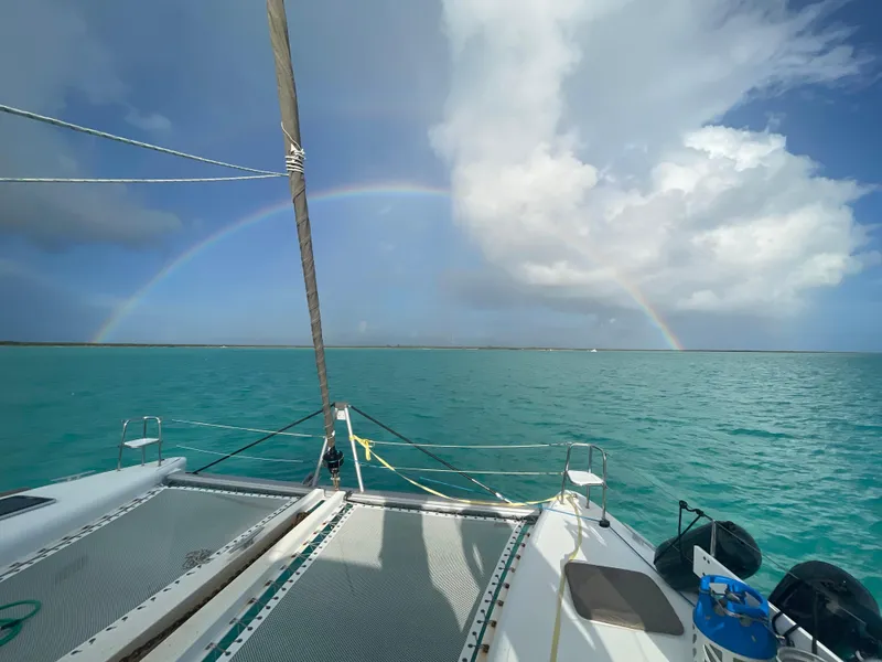 Slide: The Image of Lagoon 450 F catamaran sailing under a vibrant rainbow on turquoise waters, 2016 model. - 0