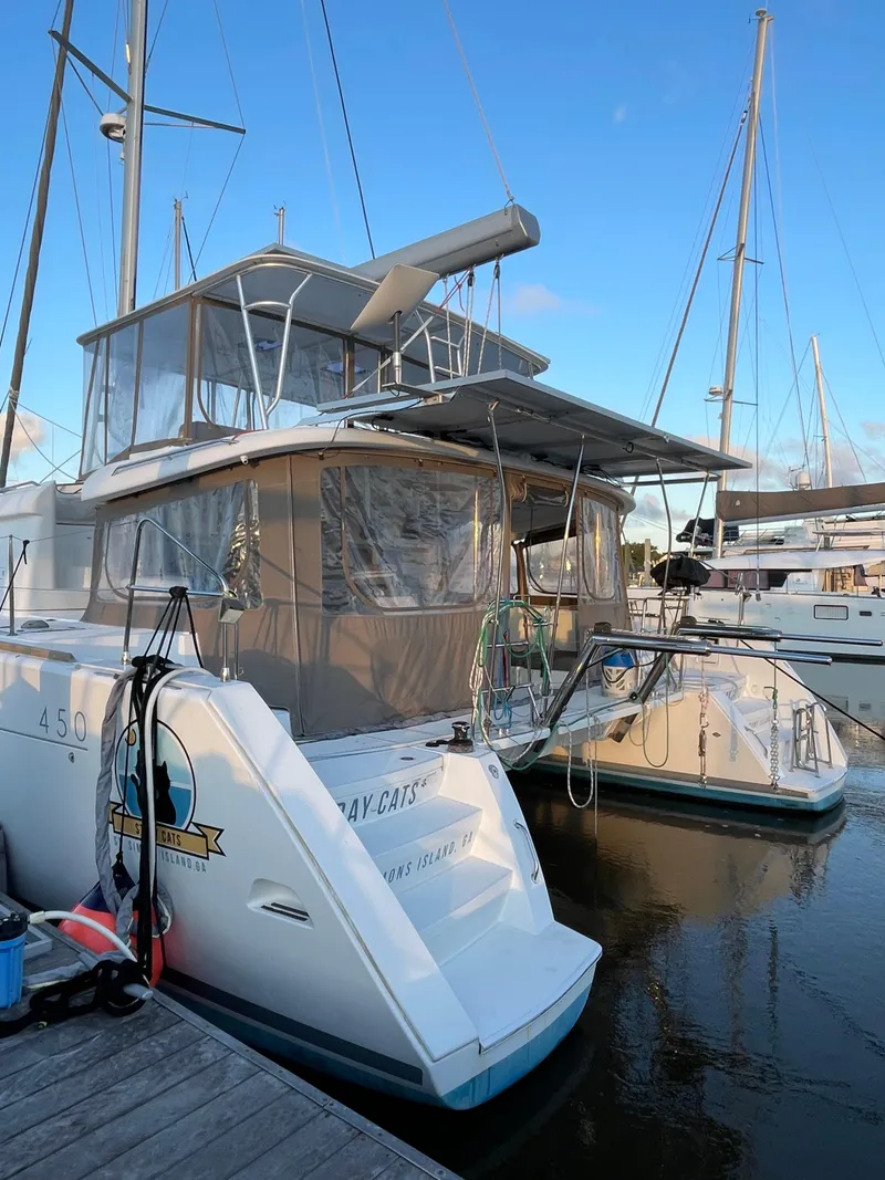 Slide: The Image of 2016 Lagoon 450 F catamaran docked at marina, featuring spacious deck and modern design. - 10