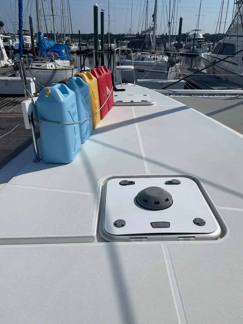 Slide: The Image of Lagoon 450 F 2016 catamaran deck with colorful fuel containers in a marina setting. - 12