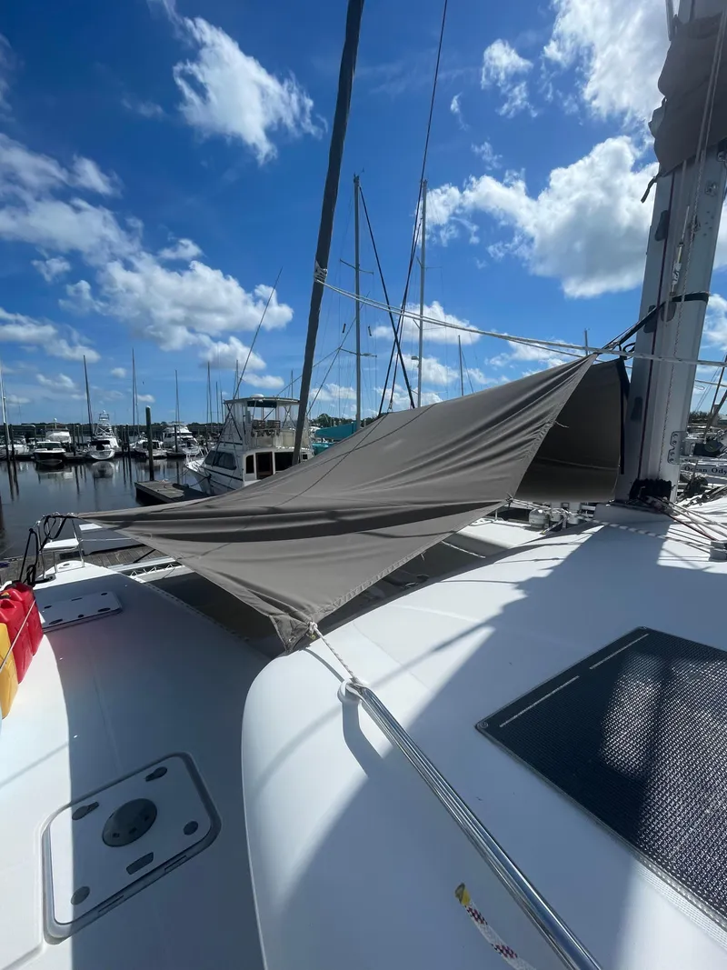 Slide: The Image of 2016 Lagoon 450 F catamaran with sunshade, docked at marina under blue sky. - 14