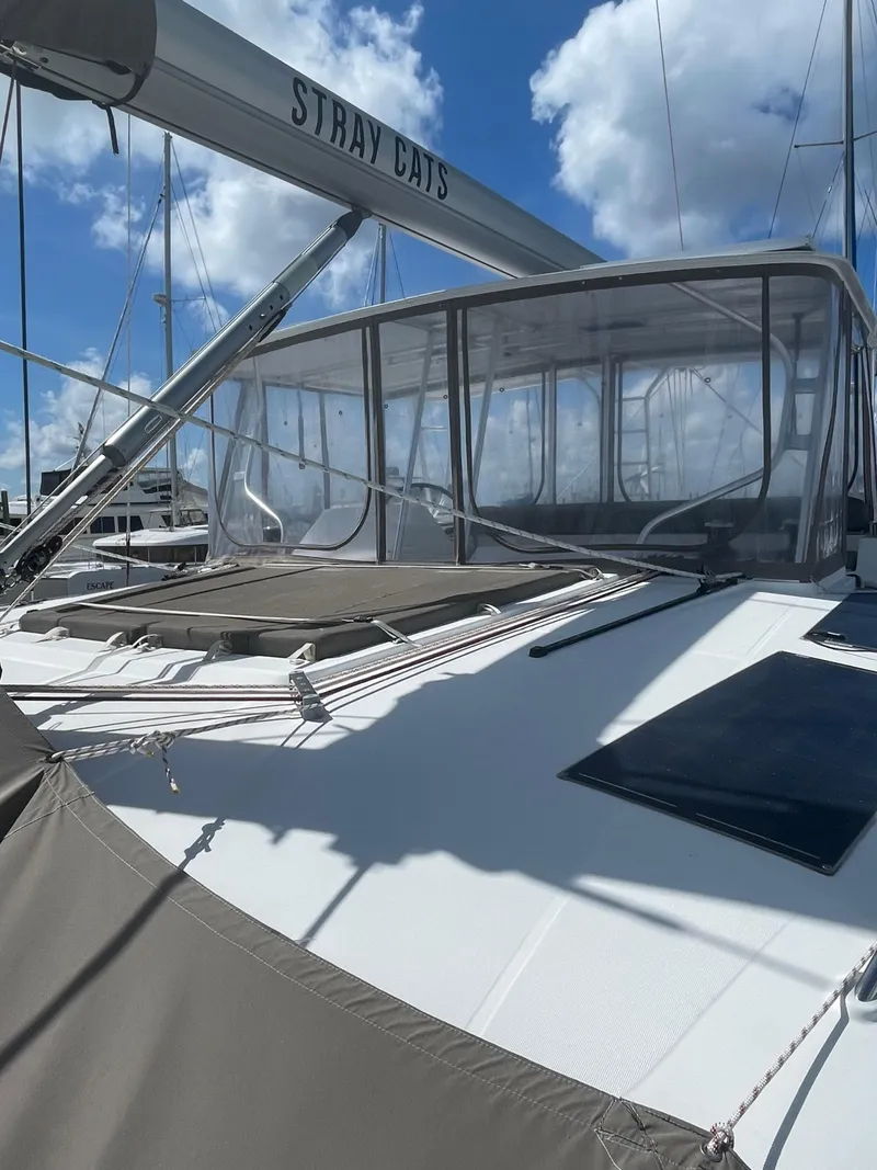 Slide: The Image of 2016 Lagoon 450 F catamaran with clear enclosure, under a blue sky. - 21