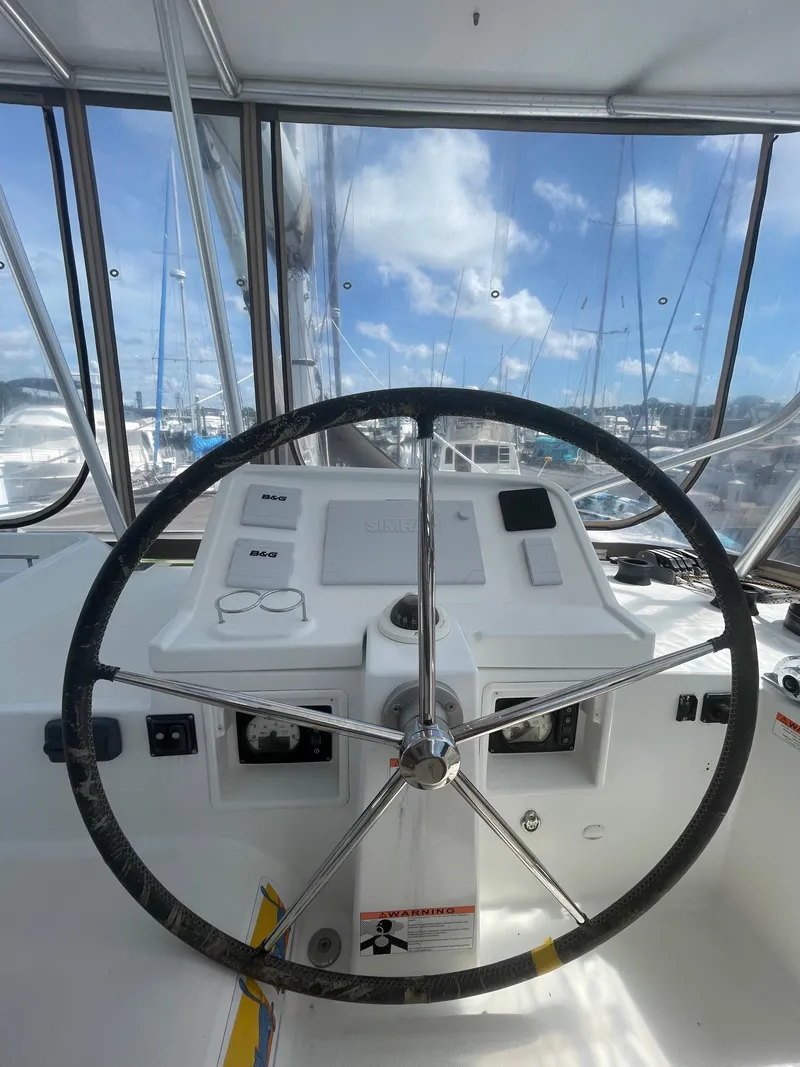 Slide: The Image of Helm of 2016 Lagoon 450 F catamaran with steering wheel and navigation controls. - 25