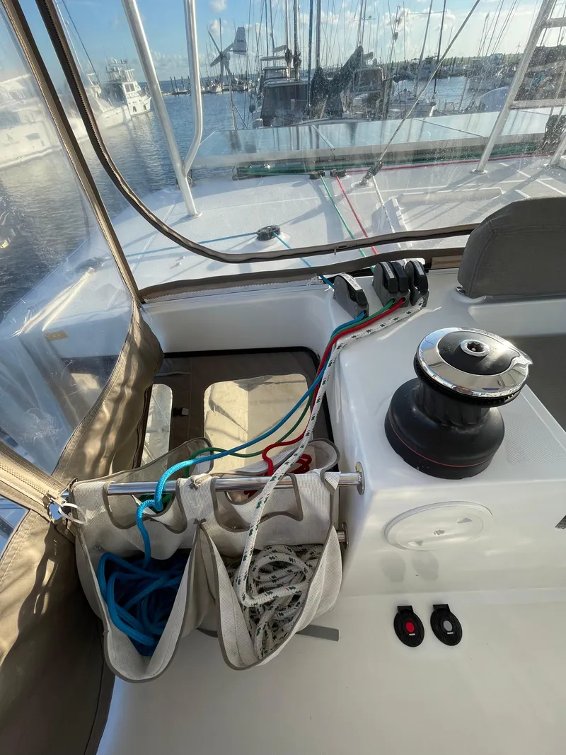 Slide: The Image of 2016 Lagoon 450 F sailboat cockpit with ropes and winch in marina setting. - 28