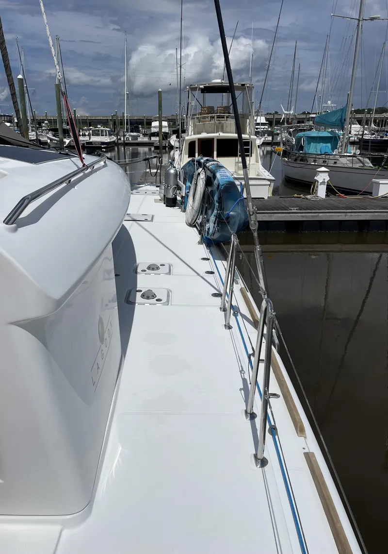 Slide: The Image of 2016 Lagoon 450 F catamaran docked at marina under cloudy sky. - 29