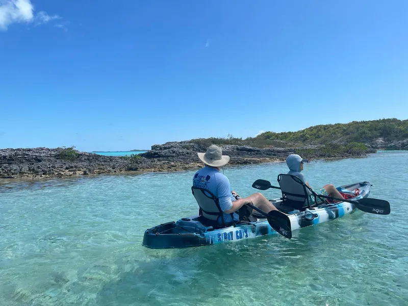 Slide: The Image of Two people kayaking in clear turquoise water under a bright blue sky. - 32