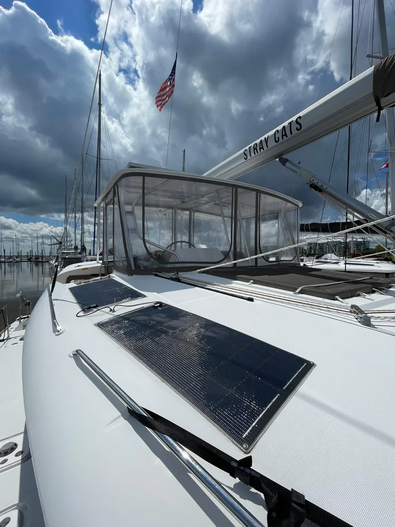 Slide: The Image of 2016 Lagoon 450 F catamaran with solar panels, docked under cloudy skies. - 33