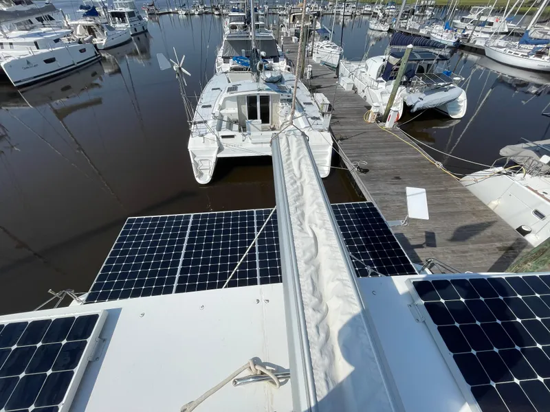 Slide: The Image of 2016 Lagoon 450 F catamaran with solar panels docked at a marina. - 35
