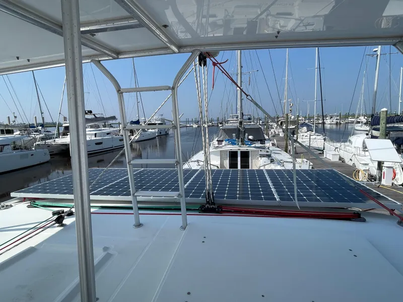 Slide: The Image of 2016 Lagoon 450 F catamaran with solar panels docked at a marina. - 37
