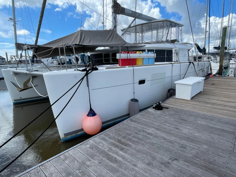 Slide: The Image of 2016 Lagoon 450 F catamaran docked at marina with clear sky. - 4