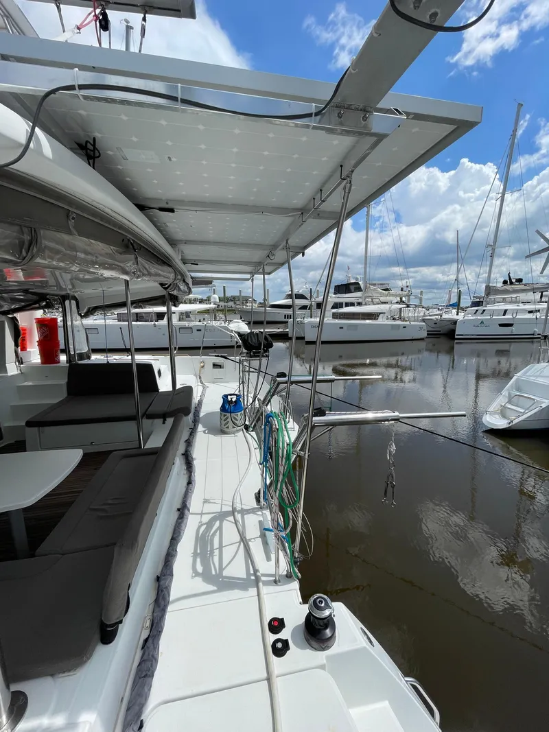Slide: The Image of 2016 Lagoon 450 F catamaran docked at marina, featuring spacious deck and solar panels. - 41