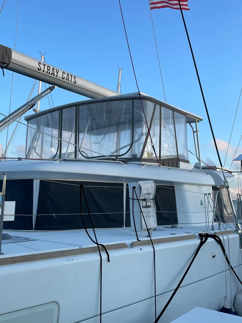 Slide: The Image of 2016 Lagoon 450 F catamaran docked, featuring sleek design and spacious upper deck. - 7