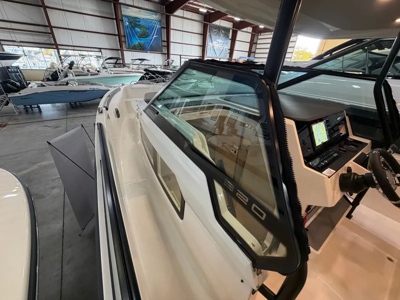 Slide: The Image of The image shows a Saxdor 320 GTO boat in a warehouse. It features a modern cockpit. - 20