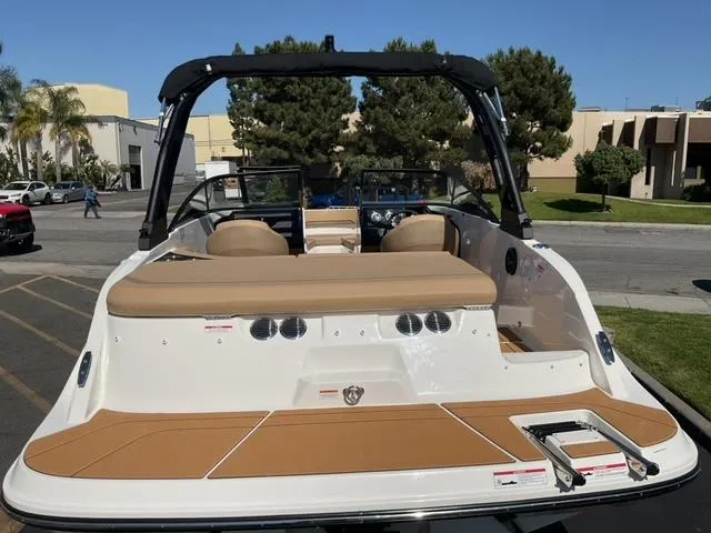 Slide: The Image of 2025 Bayliner V20i boat with tan seating and sleek design, parked outdoors. - 11