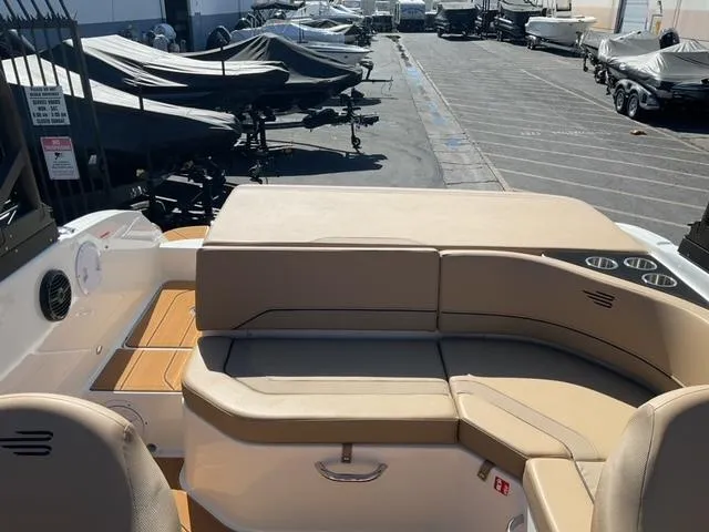 Slide: The Image of 2025 Bayliner V20i boat interior with beige seating, docked among covered boats. - 14