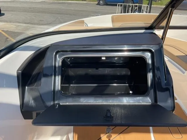 Slide: The Image of 2025 Bayliner V20i boat storage compartment with open lid, showcasing interior space. - 18