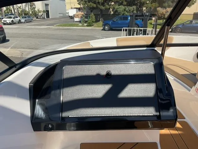 Slide: The Image of 2025 Bayliner V20i dashboard with closed compartment, outdoor setting in background. - 19