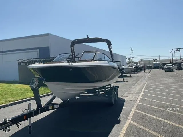 Slide: The Image of 2025 Bayliner V20i boat on trailer in parking lot, sunny day. - 2