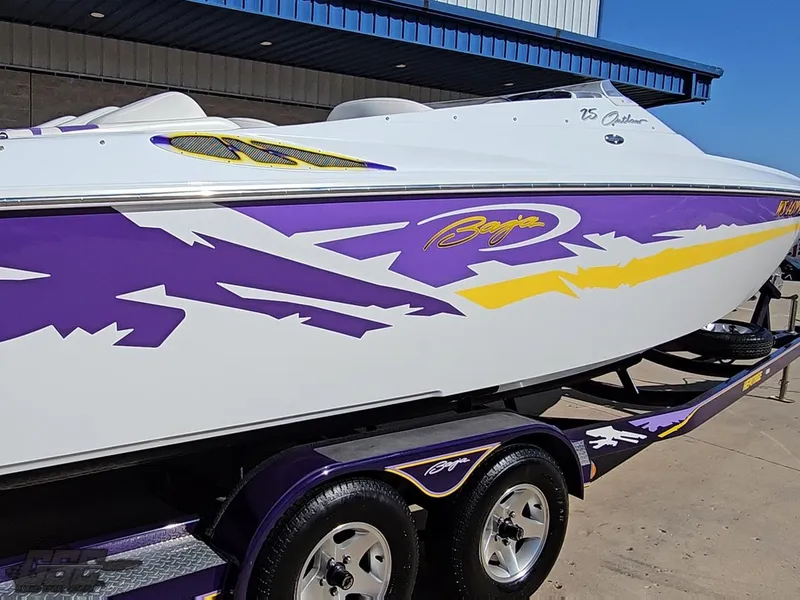 Slide: The Image of 2004 Baja 25 Outlaw boat with vibrant purple and yellow graphics on a trailer. - 10
