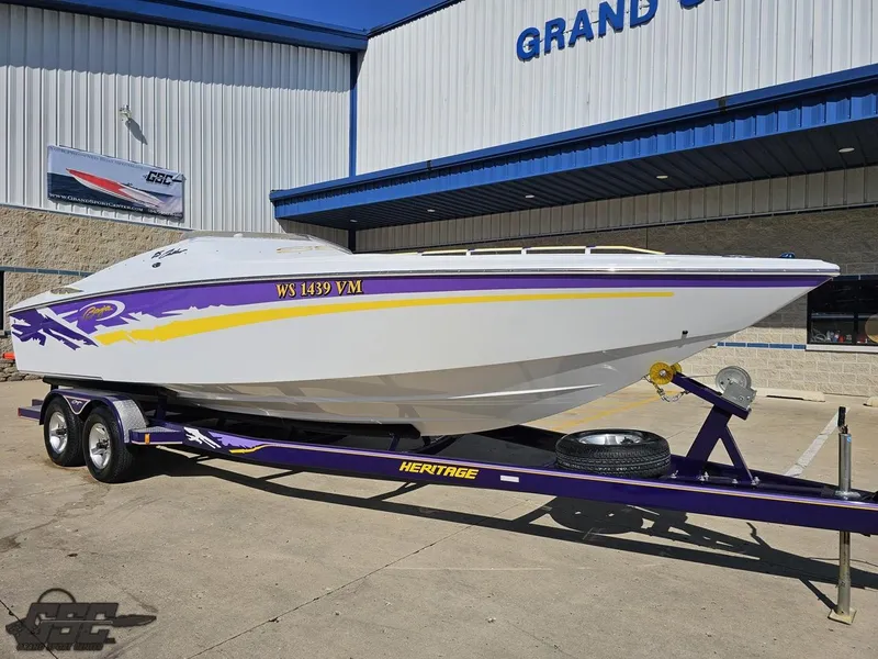 Slide: The Image of 2004 Baja 25 Outlaw boat on a purple trailer outside a dealership. - 12