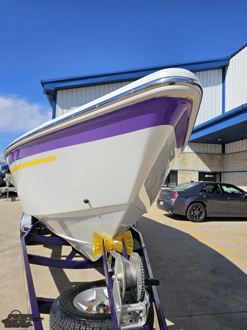 Slide: The Image of 2004 Baja 25 Outlaw boat with purple and white hull on trailer. - 14