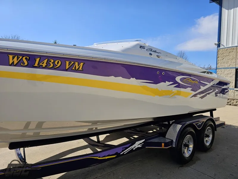 Slide: The Image of 2004 Baja 25 Outlaw boat with vibrant purple and yellow graphics on a trailer. - 18