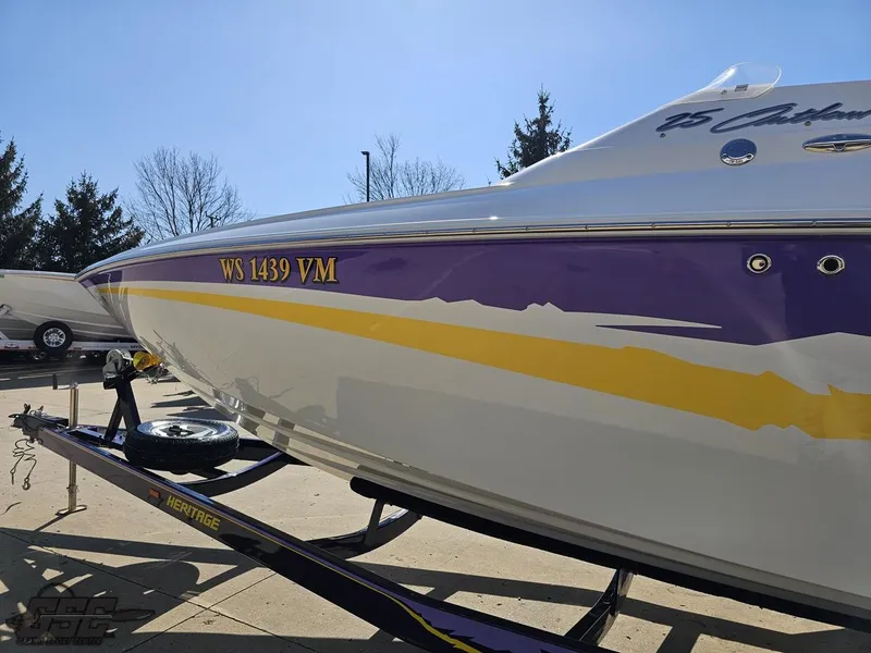 Slide: The Image of 2004 Baja 25 Outlaw boat with purple and yellow accents on a trailer. - 20