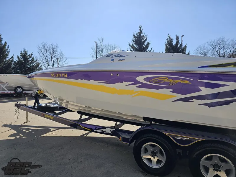 Slide: The Image of 2004 Baja 25 Outlaw boat with vibrant purple and yellow graphics on a trailer. - 21