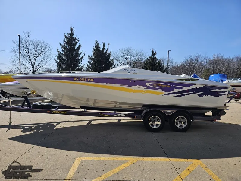 Slide: The Image of 2004 Baja 25 Outlaw speedboat on trailer, featuring vibrant purple and yellow graphics. - 23