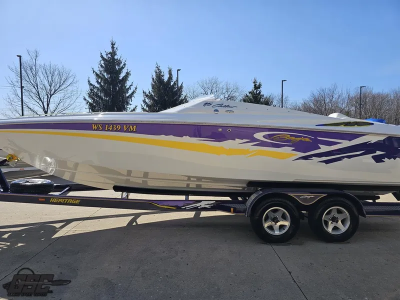 Slide: The Image of 2004 Baja 25 Outlaw speedboat with vibrant purple and yellow graphics on a trailer. - 24
