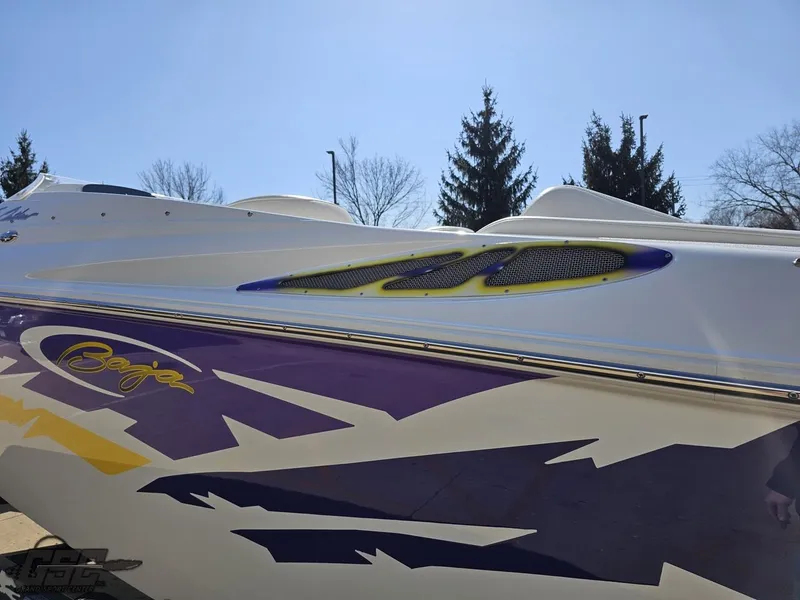 Slide: The Image of 2004 Baja 25 Outlaw boat with vibrant purple and yellow graphics. - 26