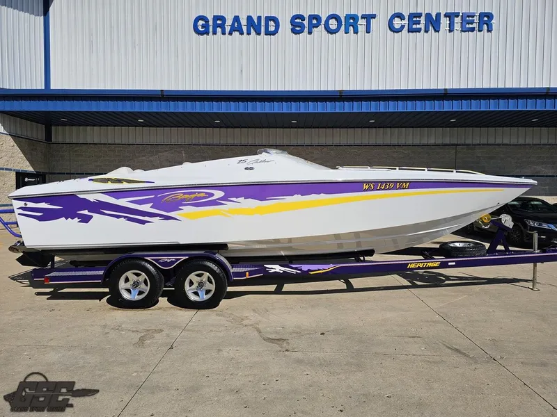 Slide: The Image of 2004 Baja 25 Outlaw speedboat with vibrant purple and yellow graphics on a trailer. - 3