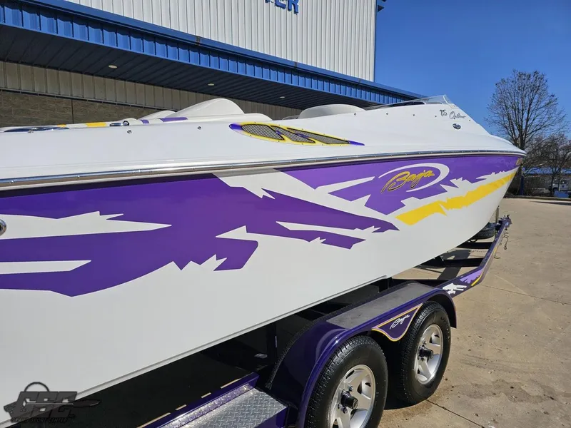 Slide: The Image of 2004 Baja 25 Outlaw speedboat with vibrant purple and yellow graphics on a trailer. - 33