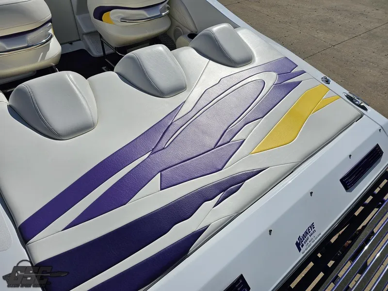 Slide: The Image of 2004 Baja 25 Outlaw boat interior with purple and yellow seat design. - 36
